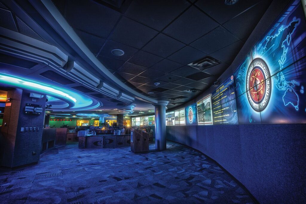 A cybersecurity analyst monitors multiple screens showing network data and security alerts.