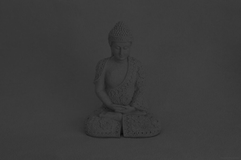 A person meditating outdoors with calm, slow breathing in a peaceful natural setting.