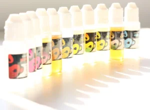 An e-cigarette and bottles of vape liquid arranged on a table.